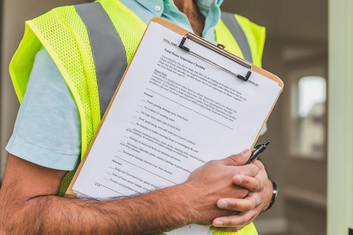Home inspector holding a clipboard checklist during a house inspection