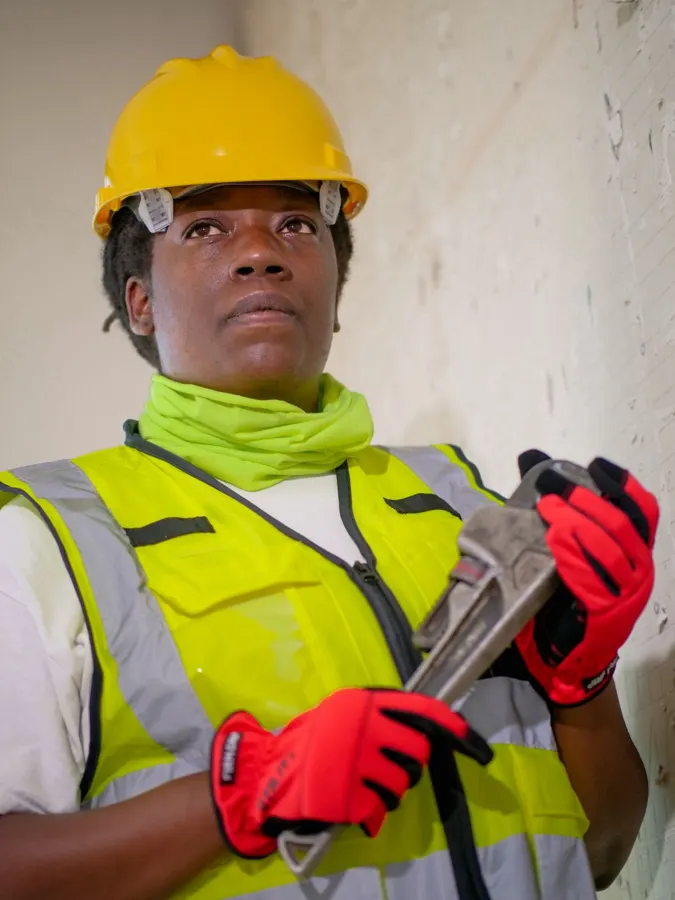 Plumber working on water supply pipes under a sink